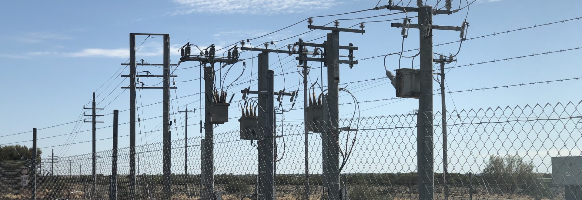 Power lines behind a chainlink fence